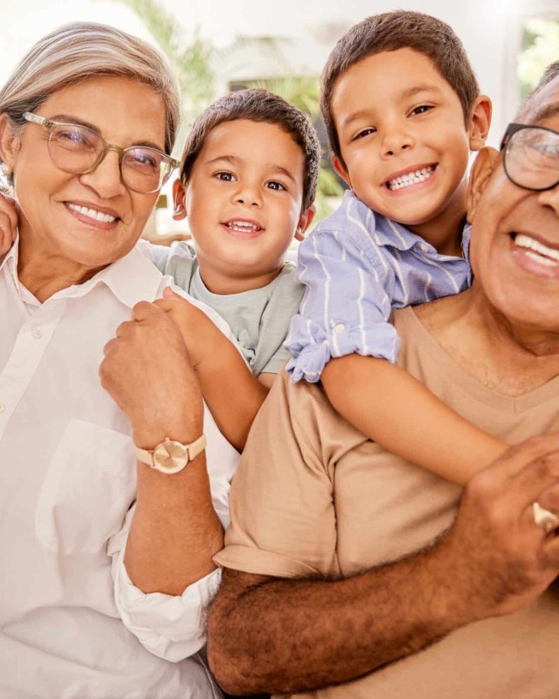 Love, happy family and kids relax with grandparents on a sofa, hug and bonding in a living room. Po